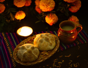 Traditional bread of the dead of Mexico, adorned with candles and cempasuchil flowers, Day of the Dead