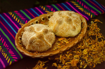 Traditional bread of the dead of Mexico, adorned with candles and cempasuchil flowers, Day of the Dead