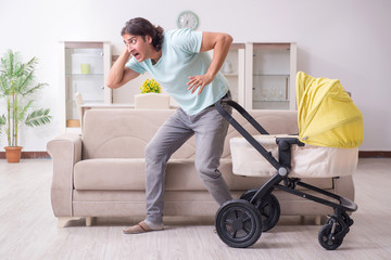 Young man looking after baby in pram
