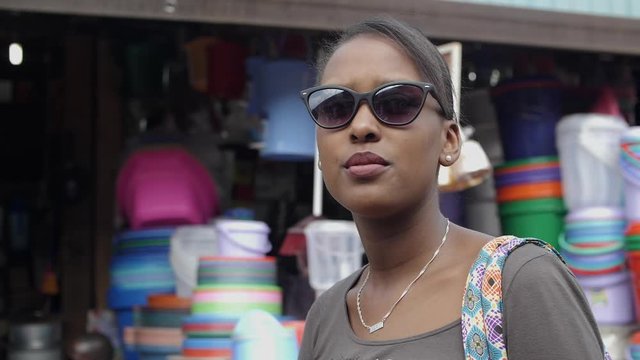 Close up view face of a woman with sunglasses walking in the market at midday slow motion