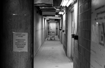 Long hallway with lights and shadow and a cart at the end