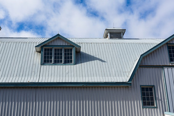 Steel barn with lines, windows and a blue sky
