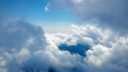 Flying through heavenly beautiful sunny cloudscape. Amazing of white fluffy clouds moving softly on the sky and the sun shining above the clouds with beautiful rays and lens flare.