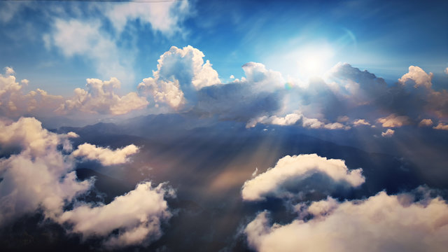 Flying through heavenly beautiful sunny cloudscape. Amazing of golden fluffy clouds moving softly on the sky and the sun shining through the clouds with beautiful rays and lens flare.