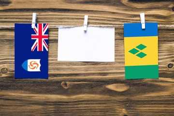 Hanging flags of Anguilla and Saint Vincent And The Grenadines attached to rope with clothes pins...