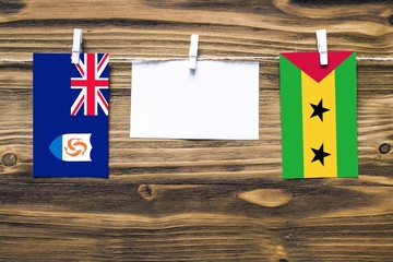 Hanging flags of Anguilla and Sao Tome And Principe attached to rope with clothes pins with copy...