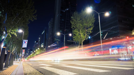 Beautiful night of Seoul road traffic, view on the busy intersection in Gangnam District. Cars, buses and other vehicles passing by creating picturesque light trails.