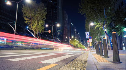 Beautiful night of Seoul road traffic, view on the busy intersection in Gangnam District. Cars, buses and other vehicles passing by creating picturesque light trails.