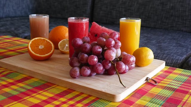Cinematic 4K "traveling" movement on fruit platter containing colorful assortment of fresh fruits : orange, lemon, watermelon and grapefruit.