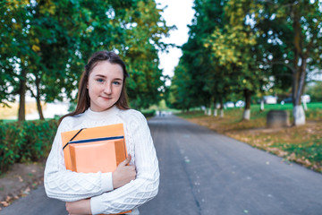 Teenager girl 15 years old autumn day summer city, hands notebooks folders with notes, happy...