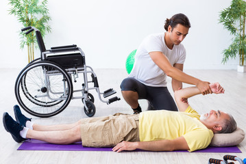 Old injured man doing exercises indoors