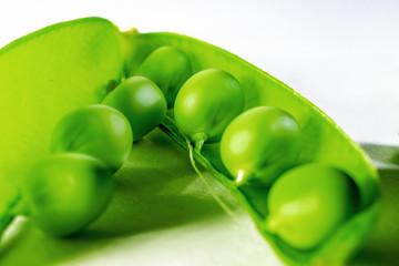 macro photo of green peas in a pod on a white background