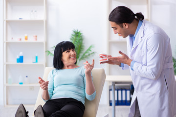 Fototapeta premium Old woman visiting young doctor dentist