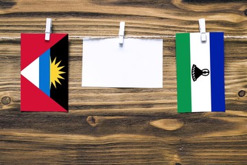 Hanging flags of Antigua and Barbuda and Lesotho attached to rope with clothes pins with copy space...