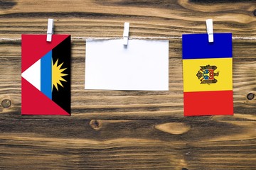 Hanging flags of Antigua and Barbuda and Moldova attached to rope with clothes pins with copy space...