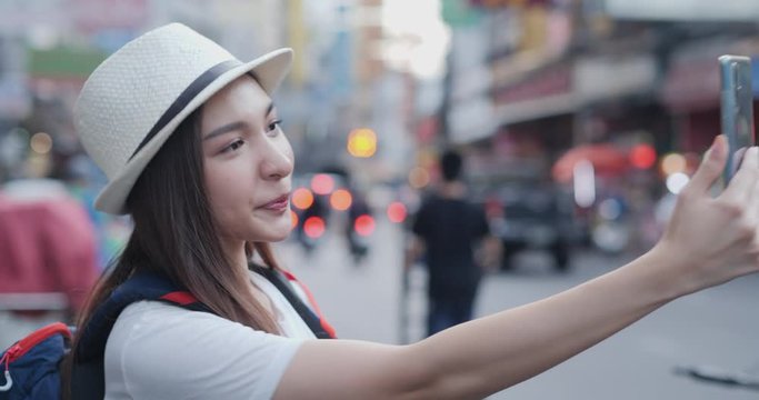 Female blogger using smartphone for live with her fanclub at city. Technology and travel concept.