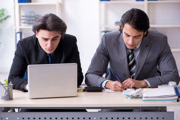Two young employees working in the office