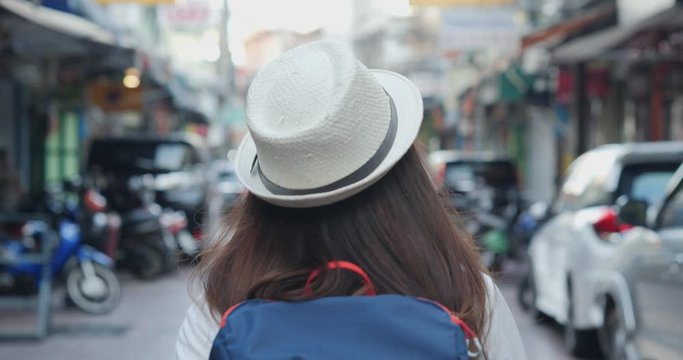 Rear view of a young woman walking the famous backpacker at bangkok.