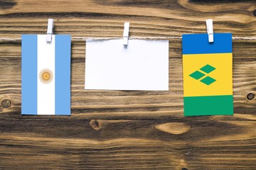 Hanging flags of Argentina and Saint Vincent And The Grenadines attached to rope with clothes pins...