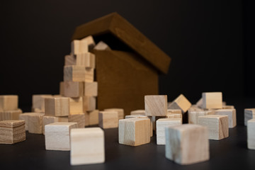 Wooden small box with wooden blocks around on the black background.Follow you dreams text on the wooden box.Stylish and textured view.