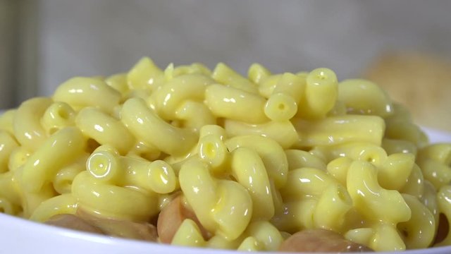 Spooning macaroni and cheese into a bowl closeup
