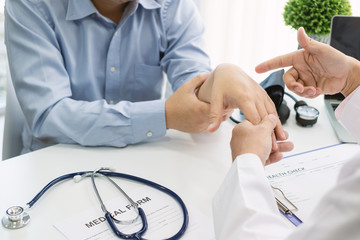 Male doctor examined the wrist for patient at the hospital.
