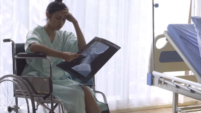 Serious patient looking at x-ray image of her brain injury surgery. Bad health result and medical malpractice concept.