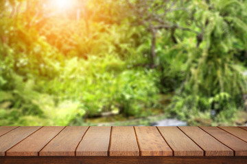 Empty wood table top on blur abstract green from garden  background.
