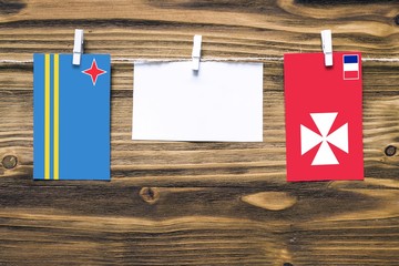 Hanging flags of Aruba and Wallis And Futuna attached to rope with clothes pins with copy space on...