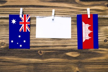 Hanging flags of Australia and Cambodia attached to rope with clothes pins with copy space on white...