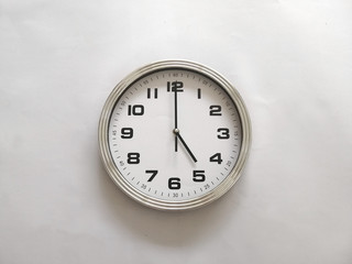 Wall clock isolated on a white wall, read at 5 o'clock. 5:00 pm, 5:00 am