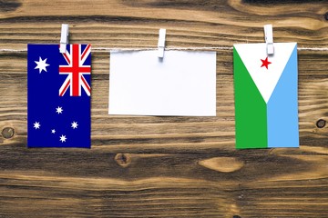 Hanging flags of Australia and Djibouti attached to rope with clothes pins with copy space on white...