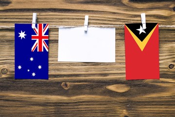 Hanging flags of Australia and East Timor attached to rope with clothes pins with copy space on...