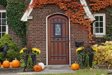 front door of house with Halloween decorations and pumpkins