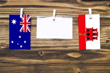 Hanging flags of Australia and Gibraltar attached to rope with clothes pins with copy space on...