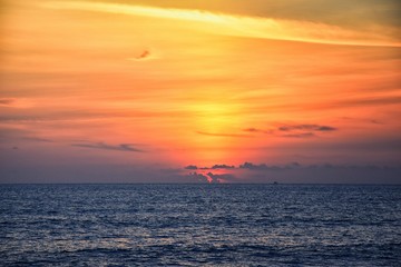 Phuket beach sunset, colorful cloudy twilight sky reflecting on the sand gazing at the Indian Ocean, Thailand, Asia.