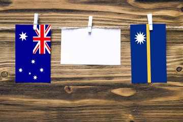 Hanging flags of Australia and Nauru attached to rope with clothes pins with copy space on white...