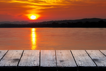Naklejka na ściany i meble Beautiful of nature background of old Wooden terrace table on Beautiful of sunset at Mekong River scenery in Chiang Khan district,Loei Thailand.Can be used for display or montage your products on top.