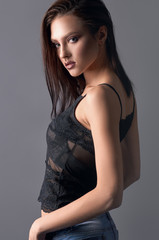 Fototapeta premium Sexy girl in lace top and ripped jeans in profile