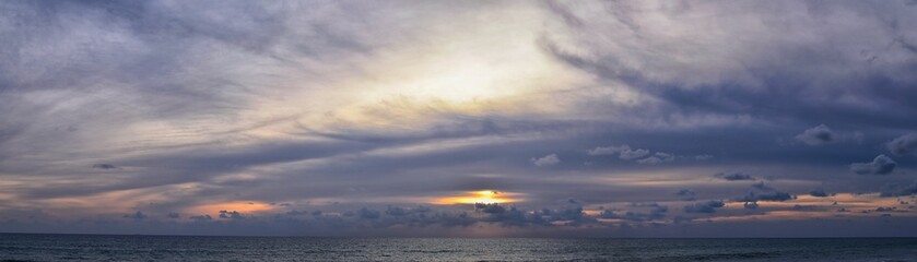 Phuket beach sunset, colorful cloudy twilight sky reflecting on the sand gazing at the Indian Ocean, Thailand, Asia.