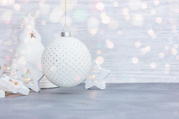 white beautiful glass ball, decorative lights and candlestick on white wooden background