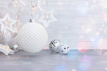 new year decorations on wooden background. light garlands in form of stars and glass balls with jingle bells for christmas home decor 