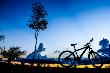 Fototapeta premium Silhouette of bicycle at the lake at sunset time in summer.
