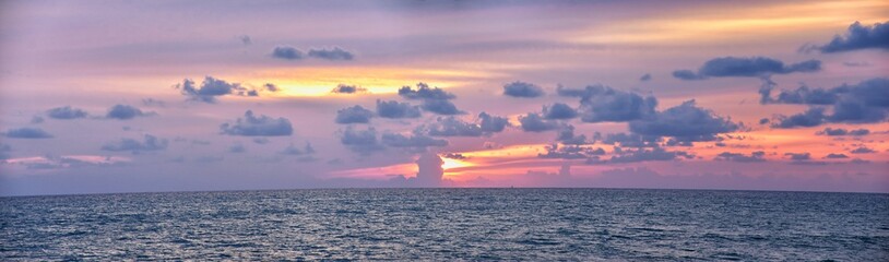 Phuket beach sunset, colorful cloudy twilight sky reflecting on the sand gazing at the Indian Ocean, Thailand, Asia.