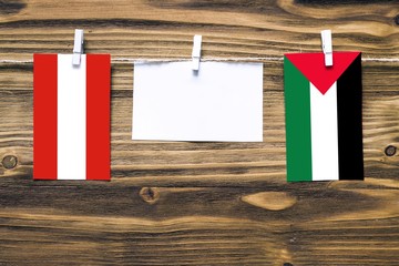 Hanging flags of Austria and Palestine attached to rope with clothes pins with copy space on white...