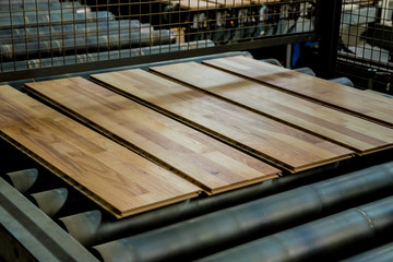 Production line of the wooden floor factory. CNC automatic woodworking machine.