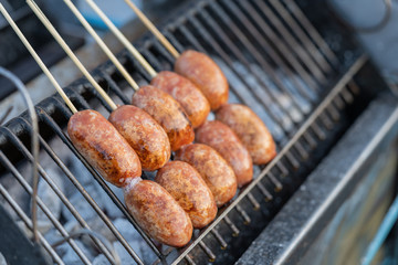 Grilling Thai sausages pork on stove. Thailand traditional street food.