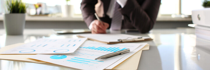 Silver pen lie at important paper on table in office