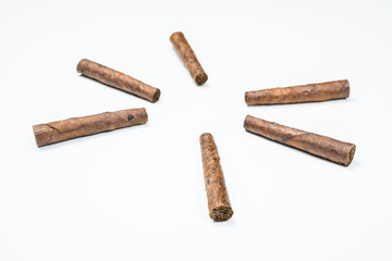 The sun laid out of twisted cigars on white background.