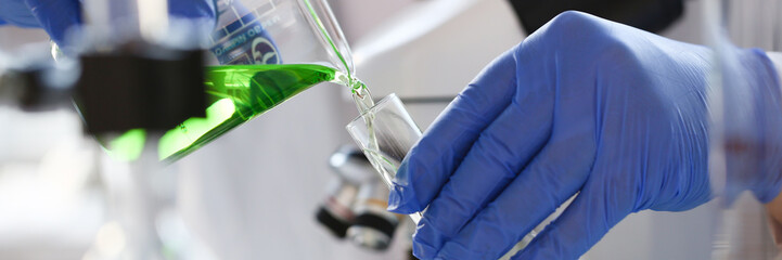 A male chemist holds test tube of glass in his hand